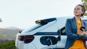 Woman waiting for electric vehicle to charge