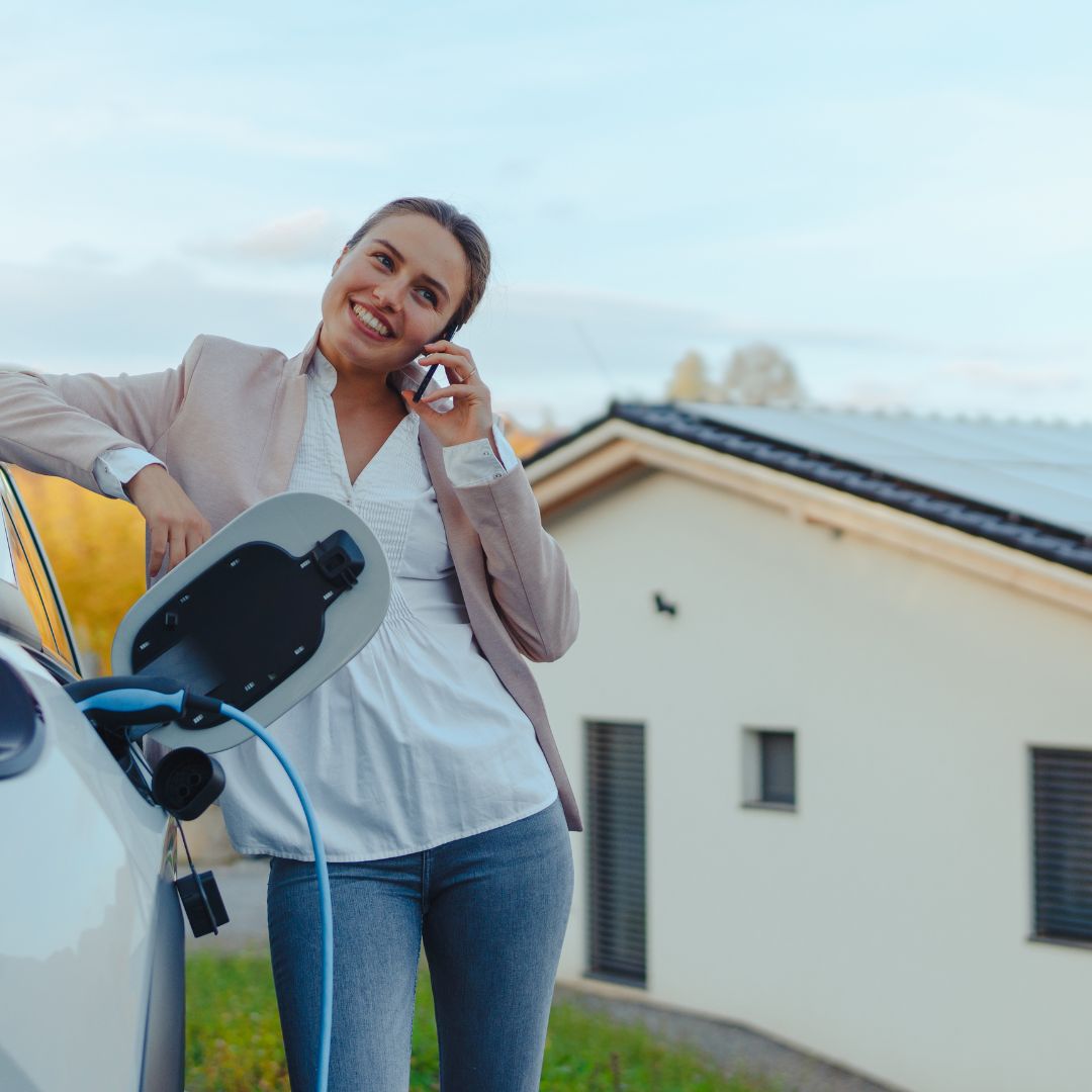 Woman charging electric vehicle at home