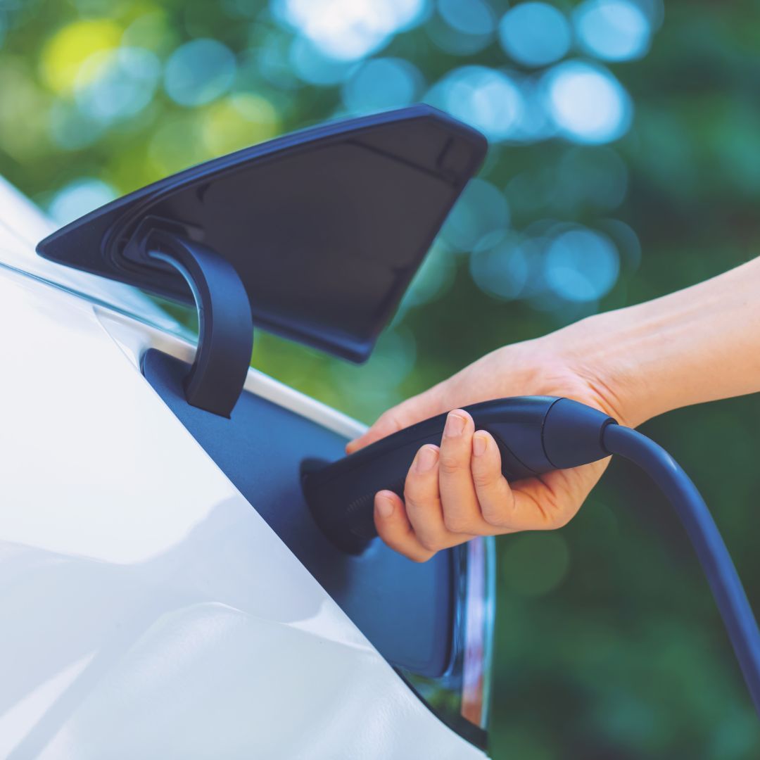 Electric vehicle being hooked up to charger